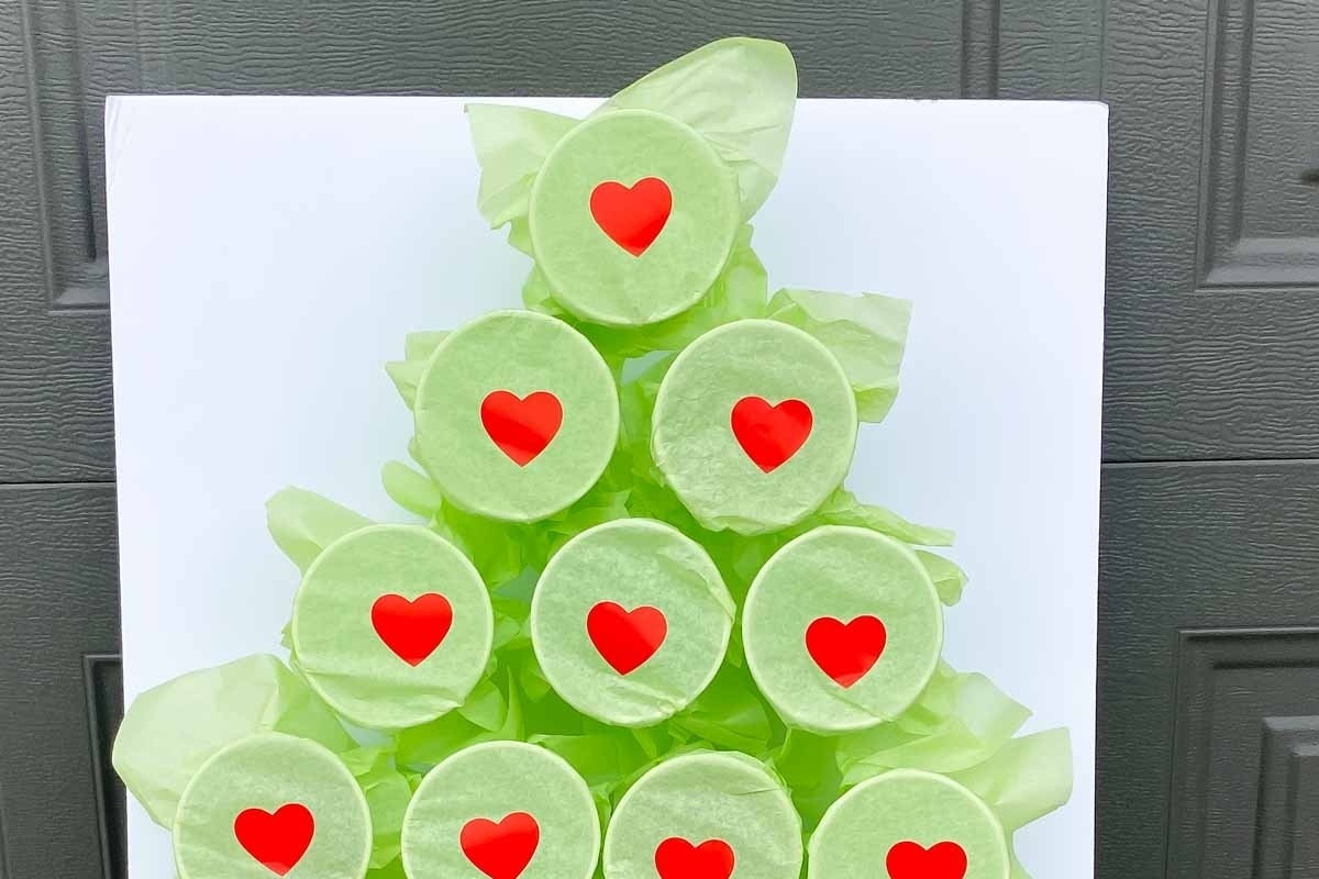 A festive Christmas tree made of vibrant green lollipops adorned with cute red hearts.
