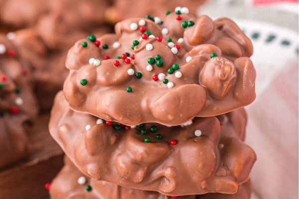 A stack of chocolate covered peanuts with sprinkles on top.