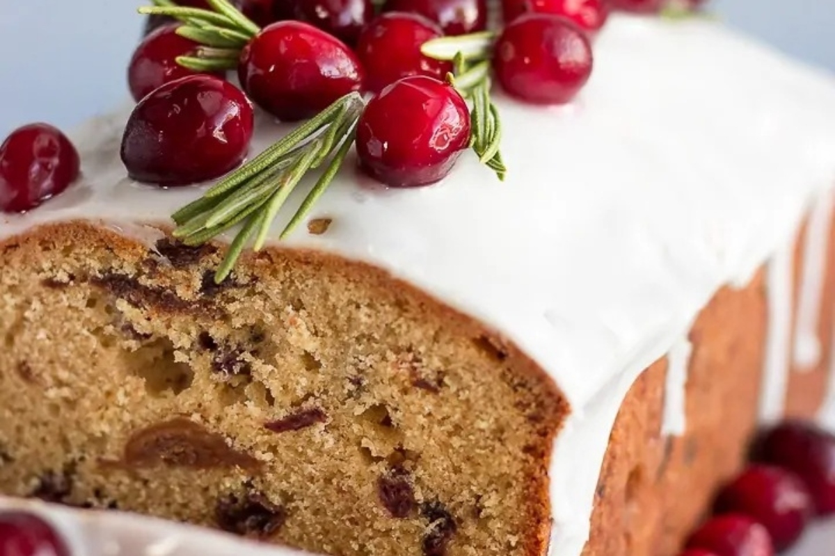 A festive Christmas cranberry cake topped with icing and cranberries.