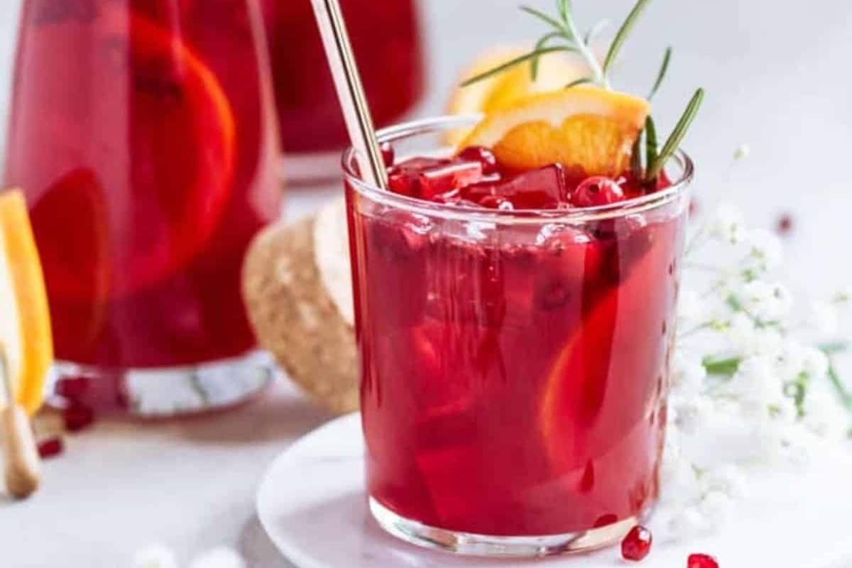Explore unique pomegranate recipes with this refreshing glass of pomegranate sangria adorned with tangy orange slices.