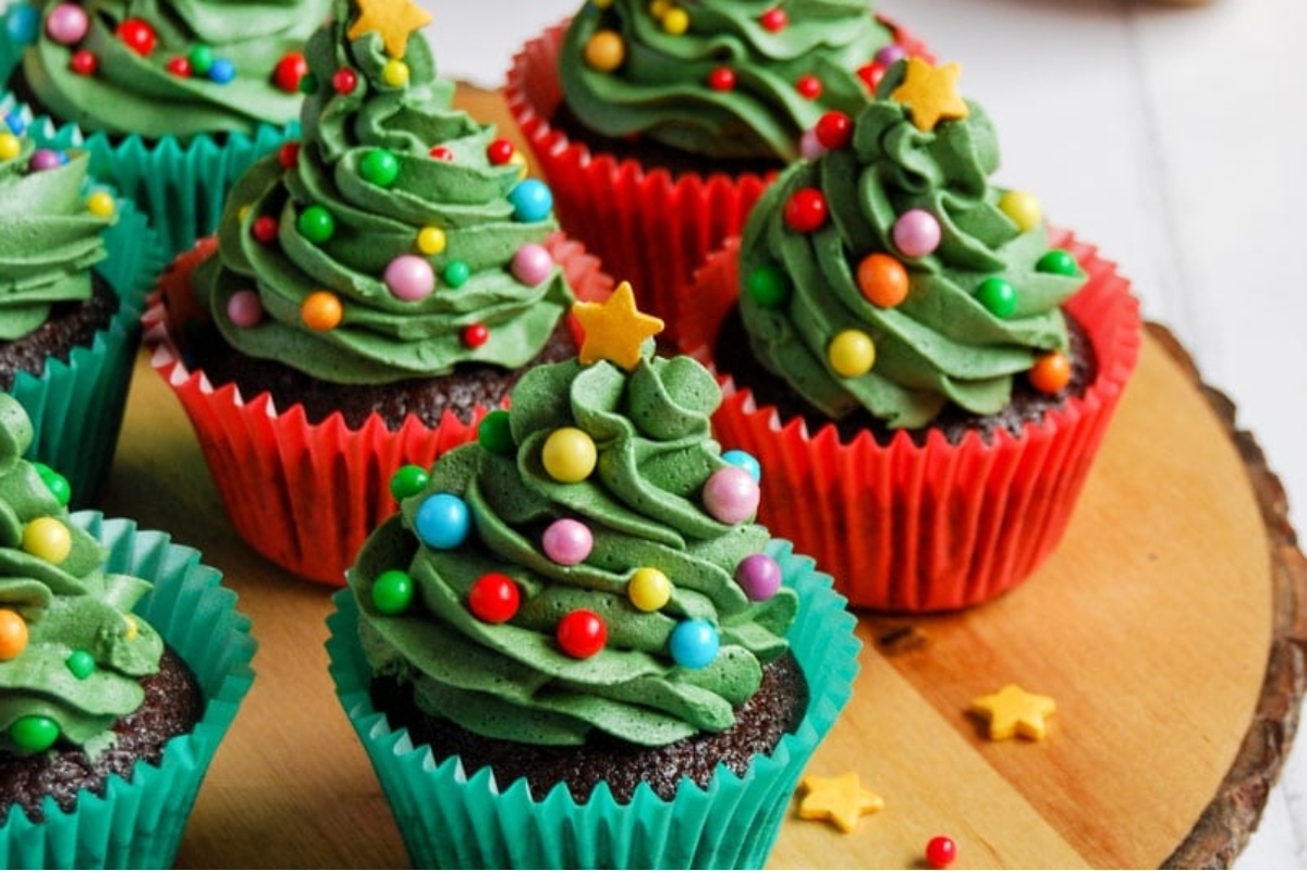 Cute Christmas tree cupcakes on a wooden plate.