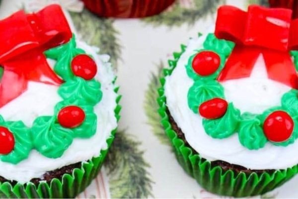 Christmas-themed cupcakes adorned with festive wreaths and holly.