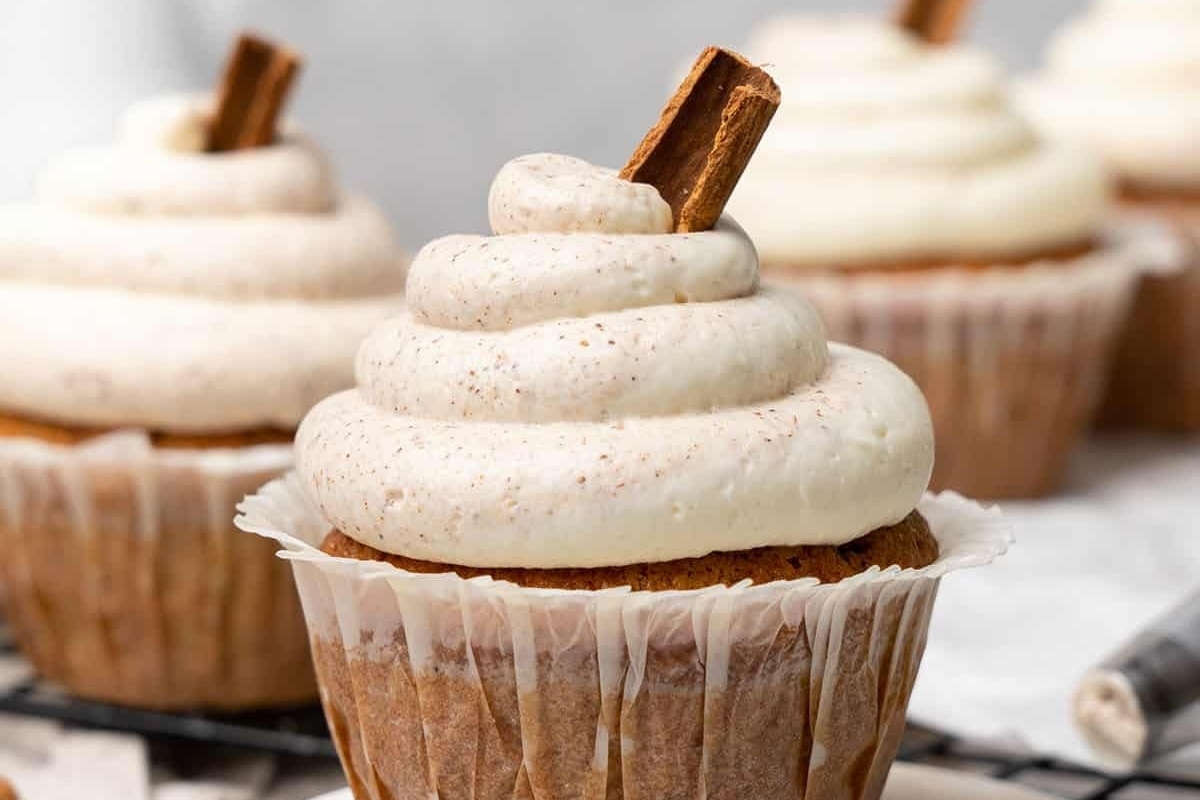 Cinnamon-spiced Pumpkin Cupcakes with a deliciously creamy icing, displayed on a cooling rack.