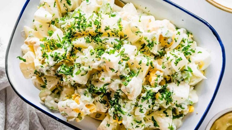 A bowl of pasta salad with parmesan cheese, parsley, and potato salad recipes.