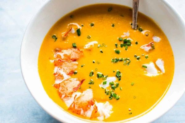A creamy soup with a spoon and broccoli.