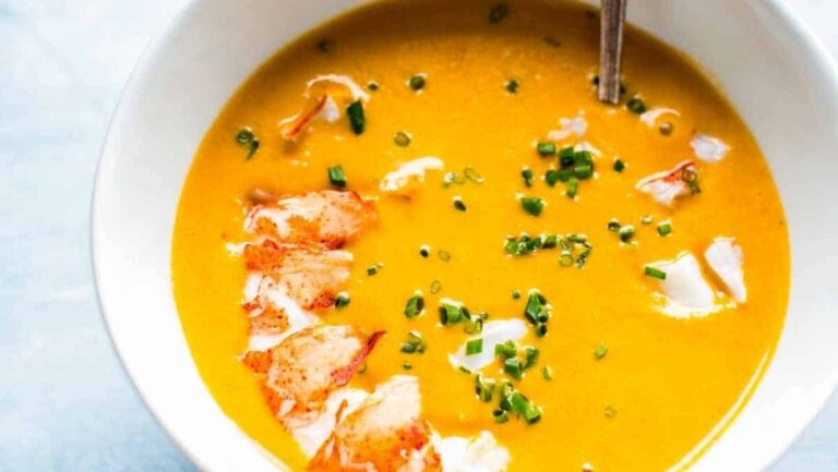 A creamy soup with a spoon and broccoli.