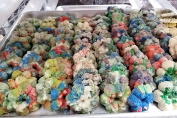 A tray full of colorful doughnuts on a table.