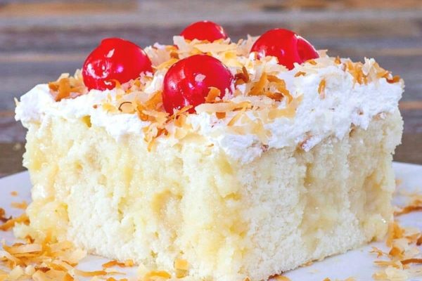 A scrumptious slice of coconut cake on a pristine white plate.