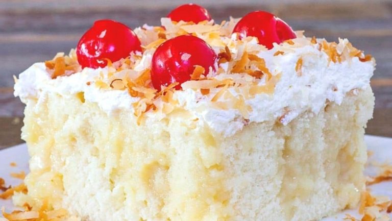 A scrumptious slice of coconut cake on a pristine white plate.