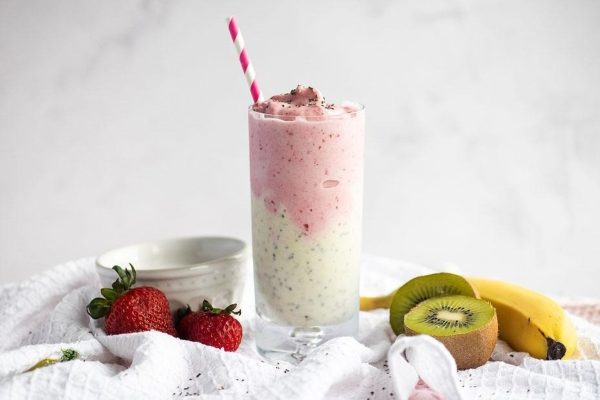 A pink smoothie with kiwi, strawberries and coconut.