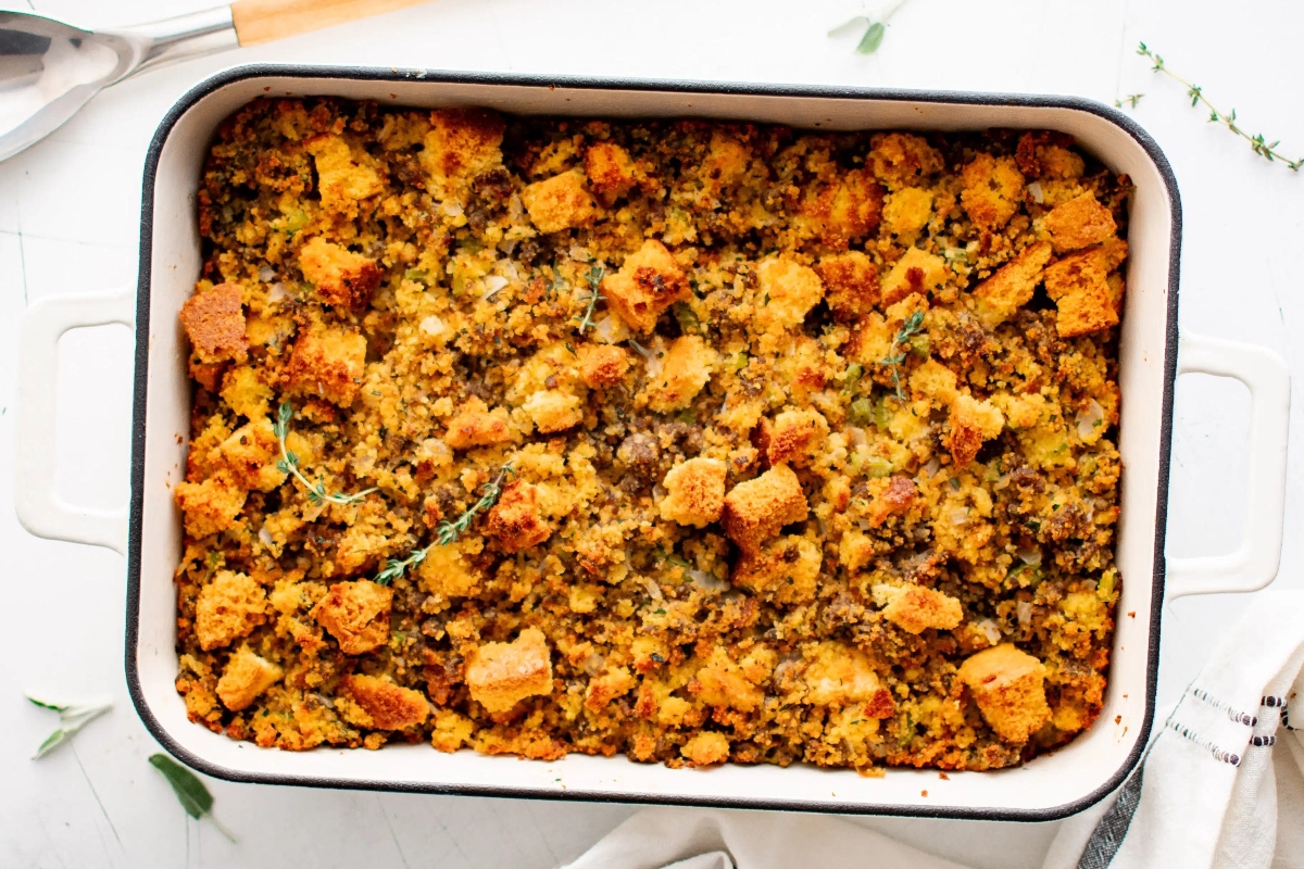 Thanksgiving stuffing in a white dish with sprigs of thyme.