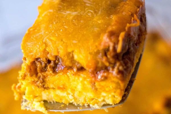 A piece of cheesy breakfast casserole on a fork.
