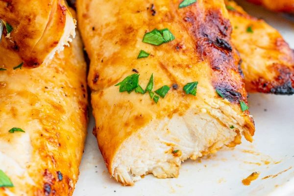 Grilled chicken breasts on a white plate.