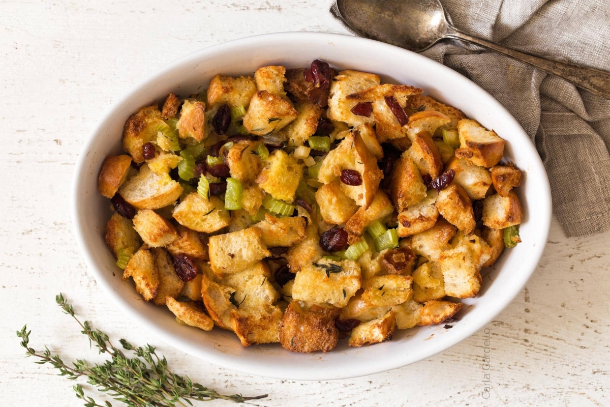 A delicious stuffing recipe topped with cranberries and sprigs of thyme.