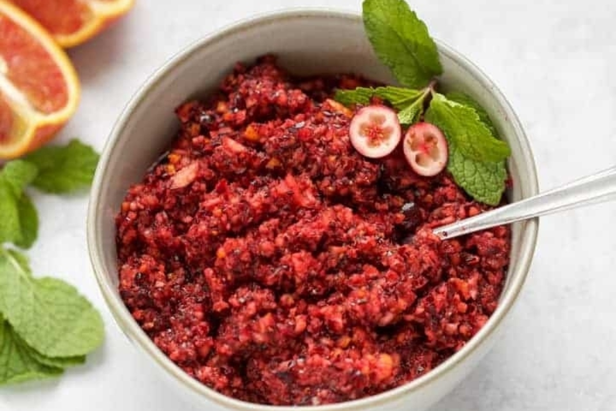 A bowl of cranberry relish with a spoon.