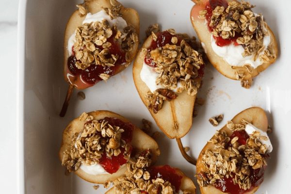Pears topped with granola and jam.