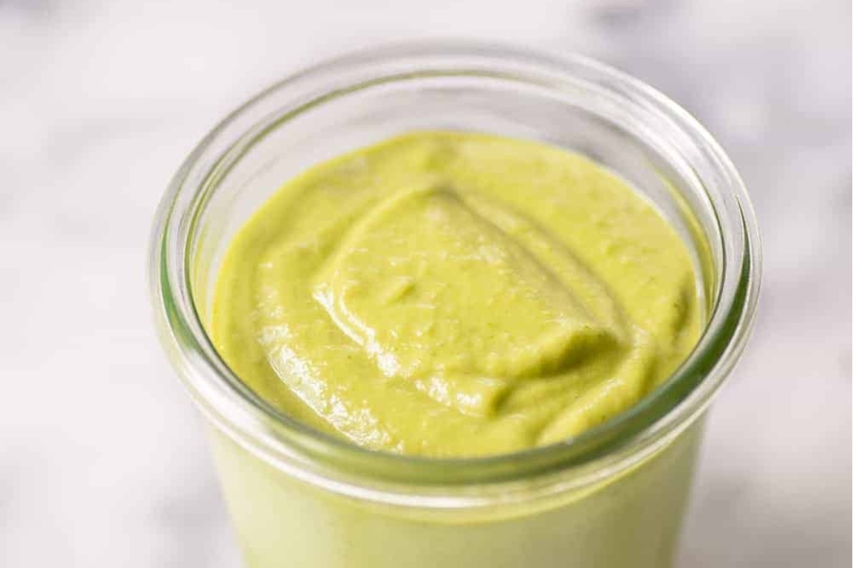 A green smoothie in a glass jar.
