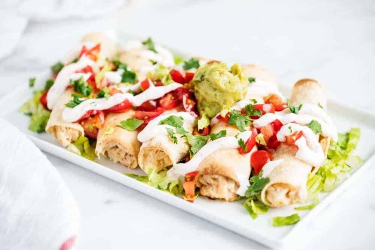 Festive Mexican enchiladas on a white plate.