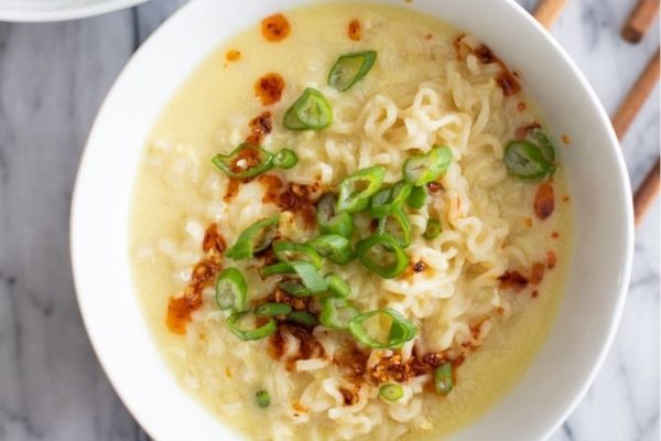 A bowl of asian noodle soup with chopsticks.