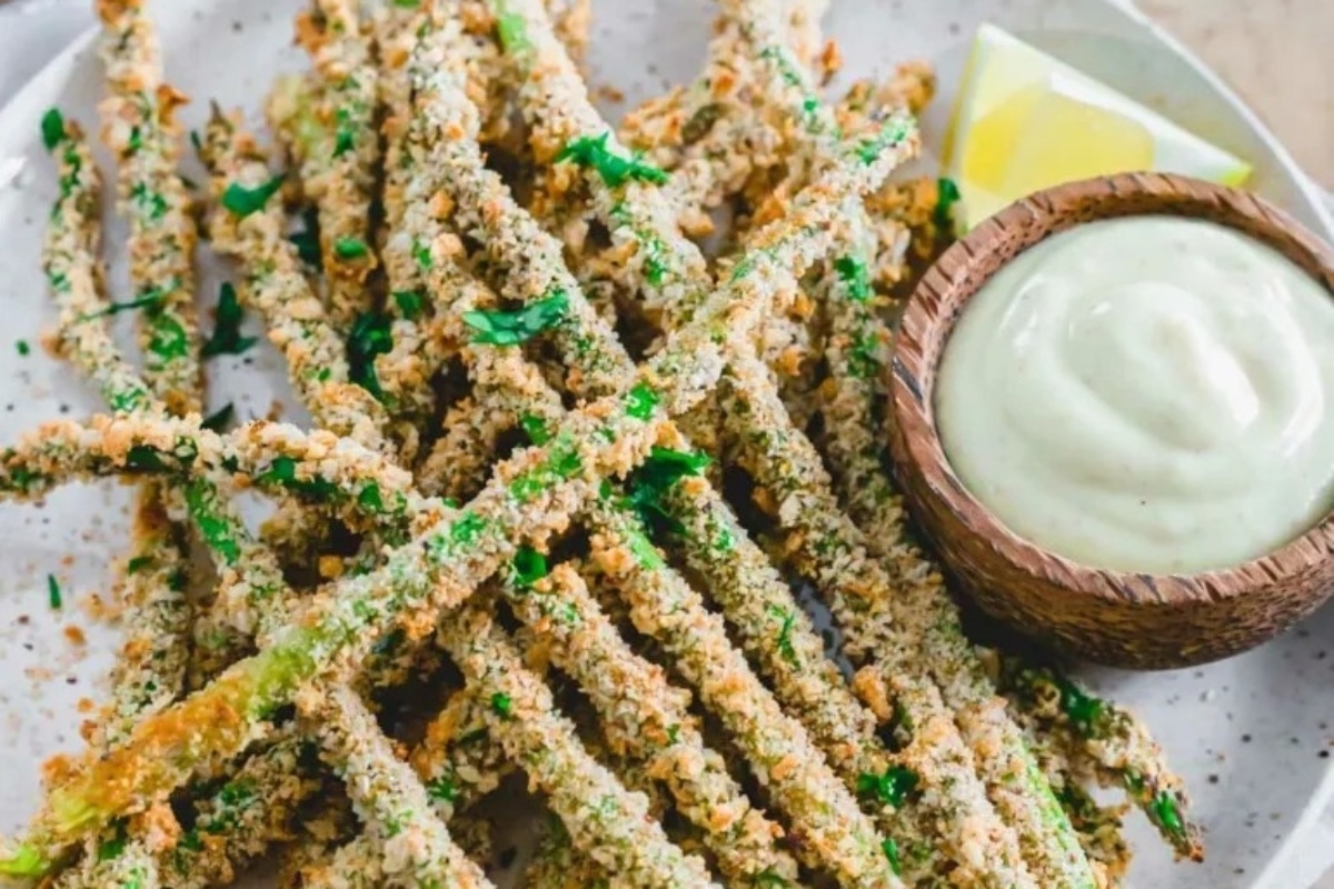 A plate of fried asparagus with dipping sauce. Are you interested in trying new fry recipes? Look no further than this scrumptious dish of fried asparagus. Enjoy the crispy texture and