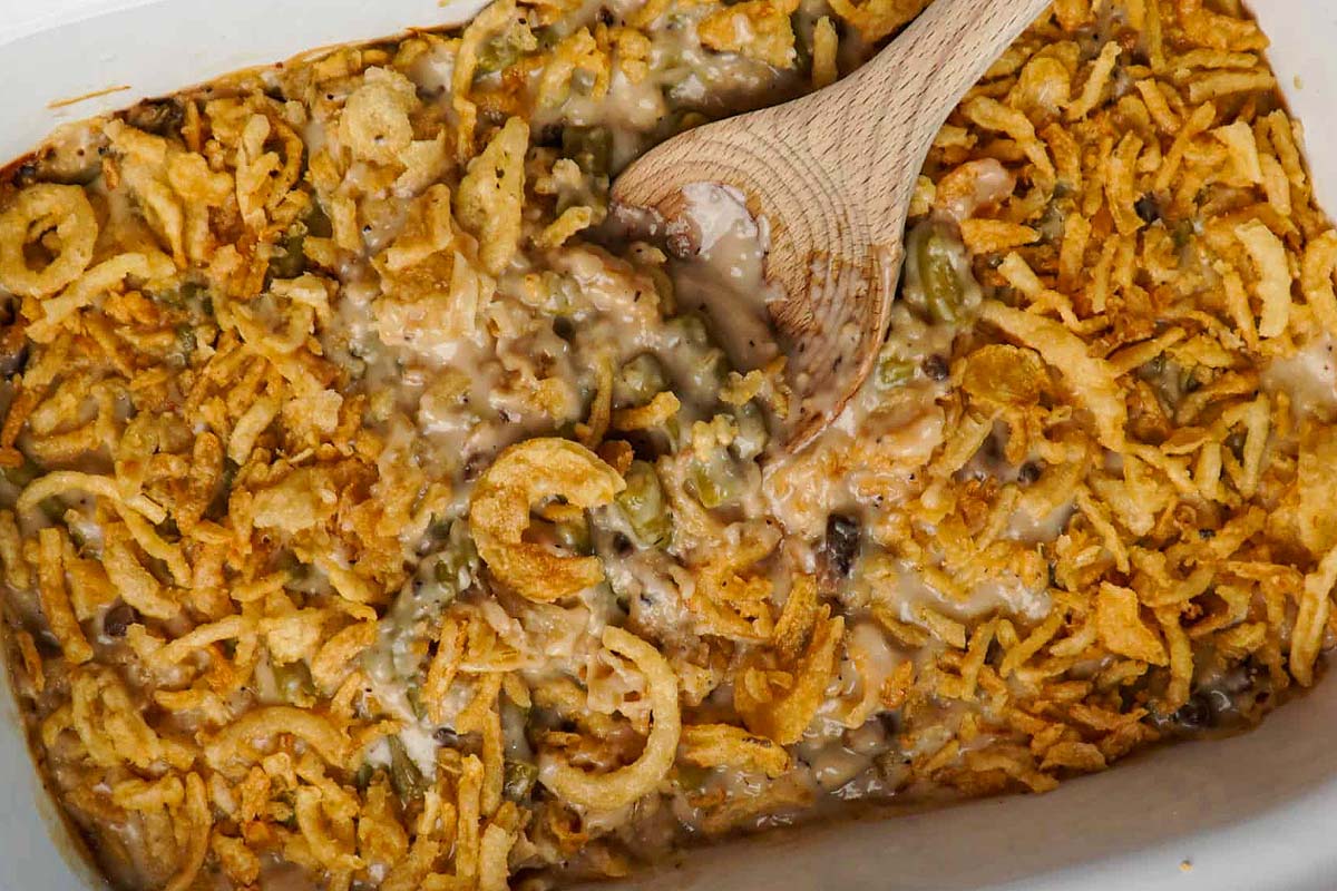 A Thanksgiving casserole dish with a wooden spoon in it.