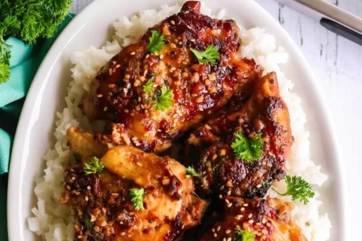 A white plate with chicken and rice on it.