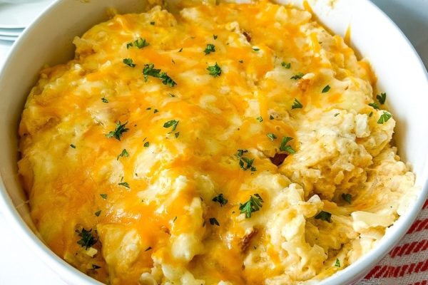 Cheesy chicken casserole in a white bowl.