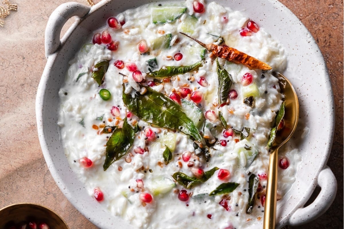 A pomegranate rice recipe served with a spoon.