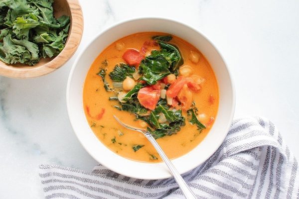 A bowl of tomato soup with a spoon.