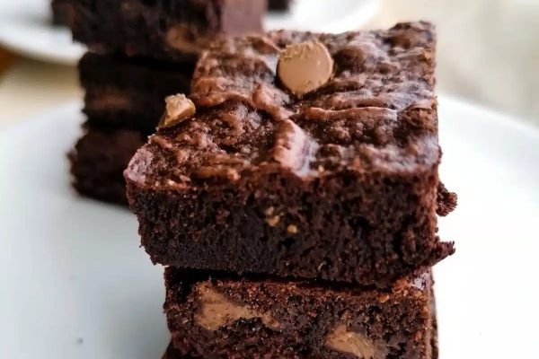 A stack of chocolate brownies on a plate, perfect for any dessert recipe.
