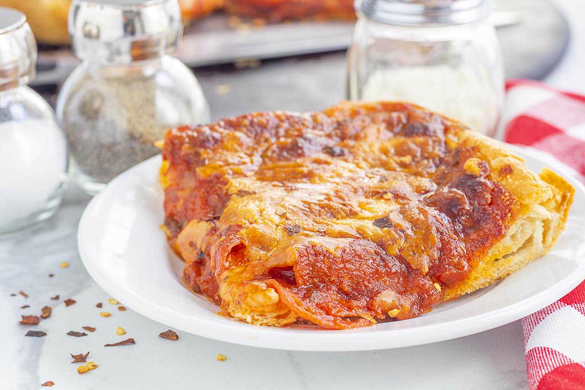 A slice of pizza on a plate.