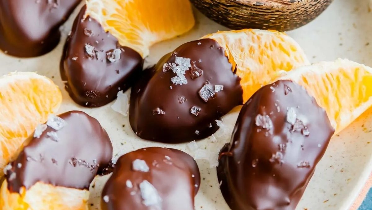 Delicious chocolate covered orange slices arranged on a plate.