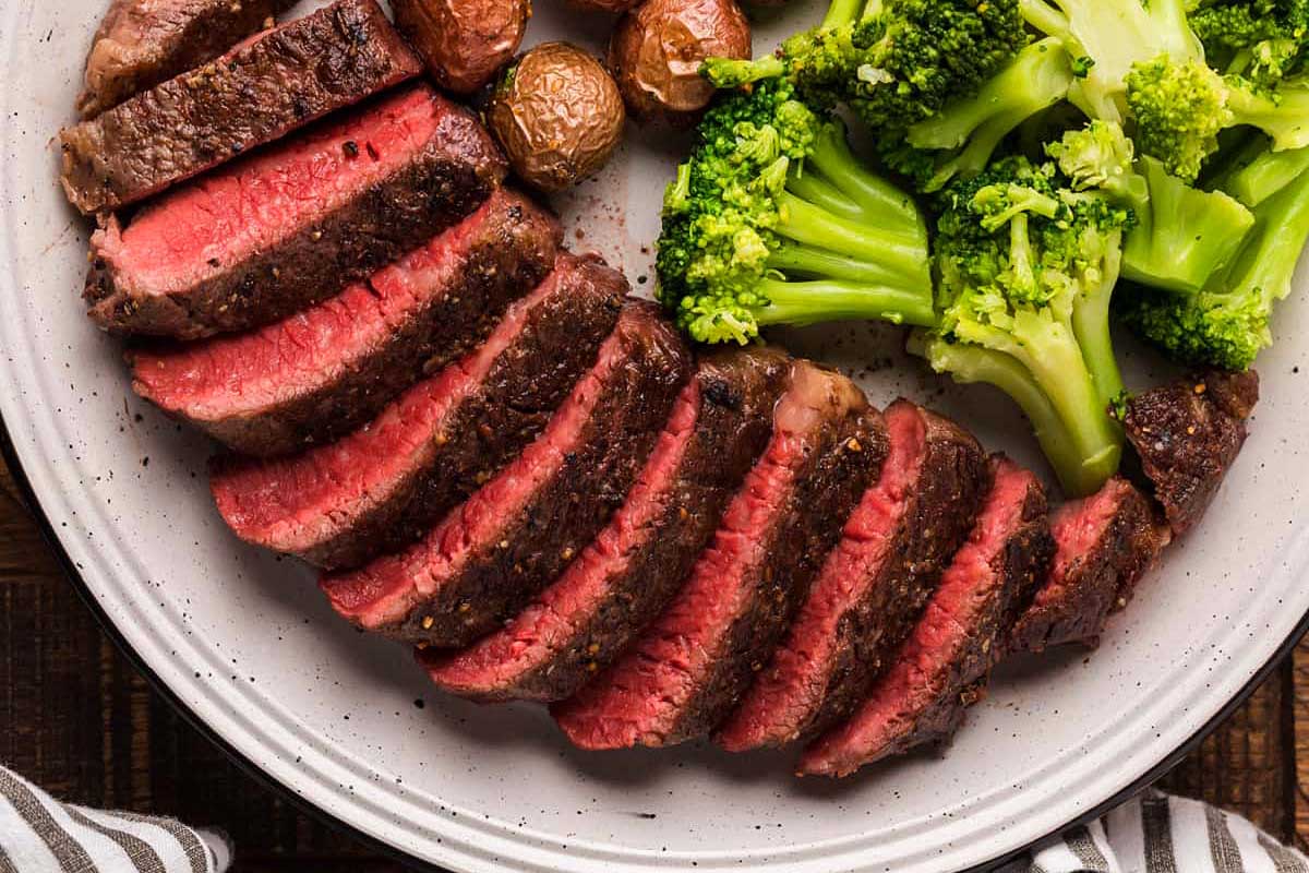 Steak with broccoli and potatoes on a plate.