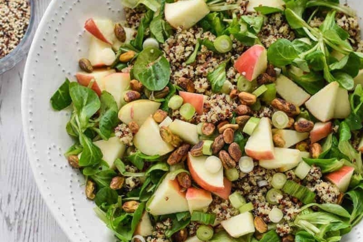 Quinoa salad prepared for meal prep with apples and pistachios.