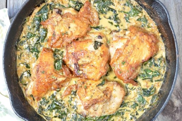 Bone In Chicken Breast and spinach in a skillet.