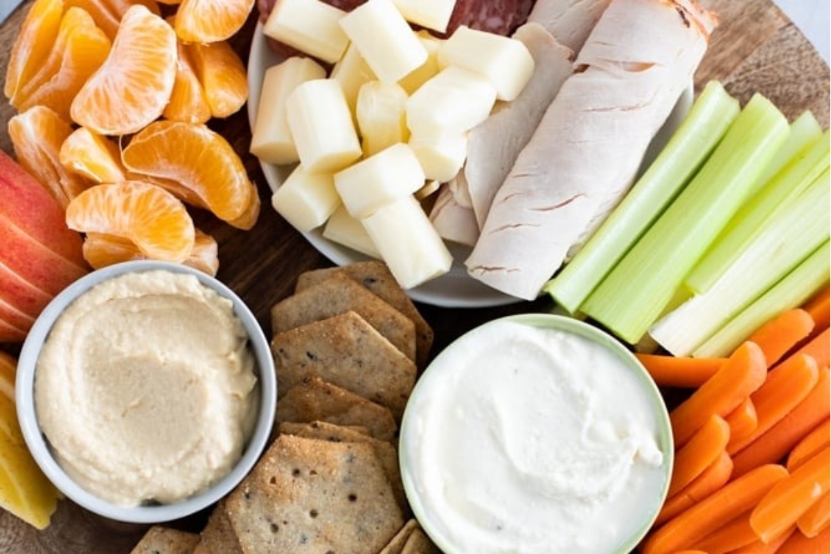 A platter with carrots, celery, crackers and dip suitable for picky eaters.