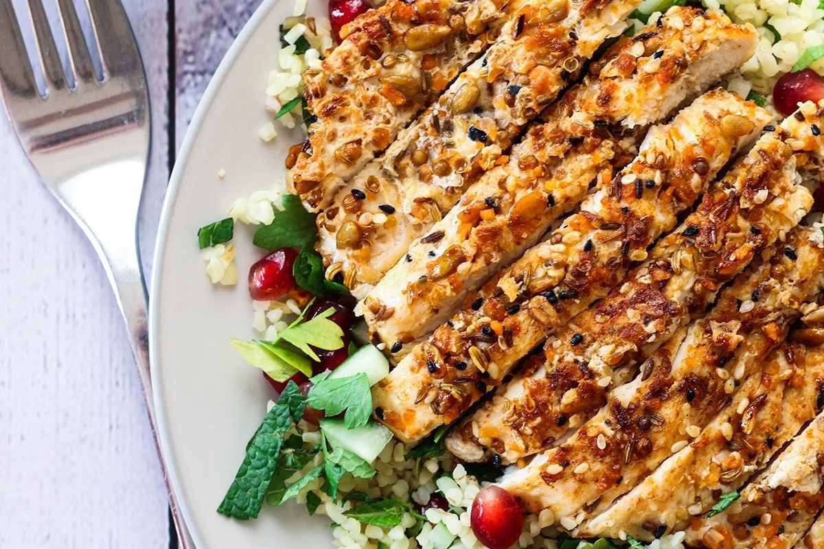 A plate of chicken salad with quinoa and pomegranate featuring a delightful blend of flavors.