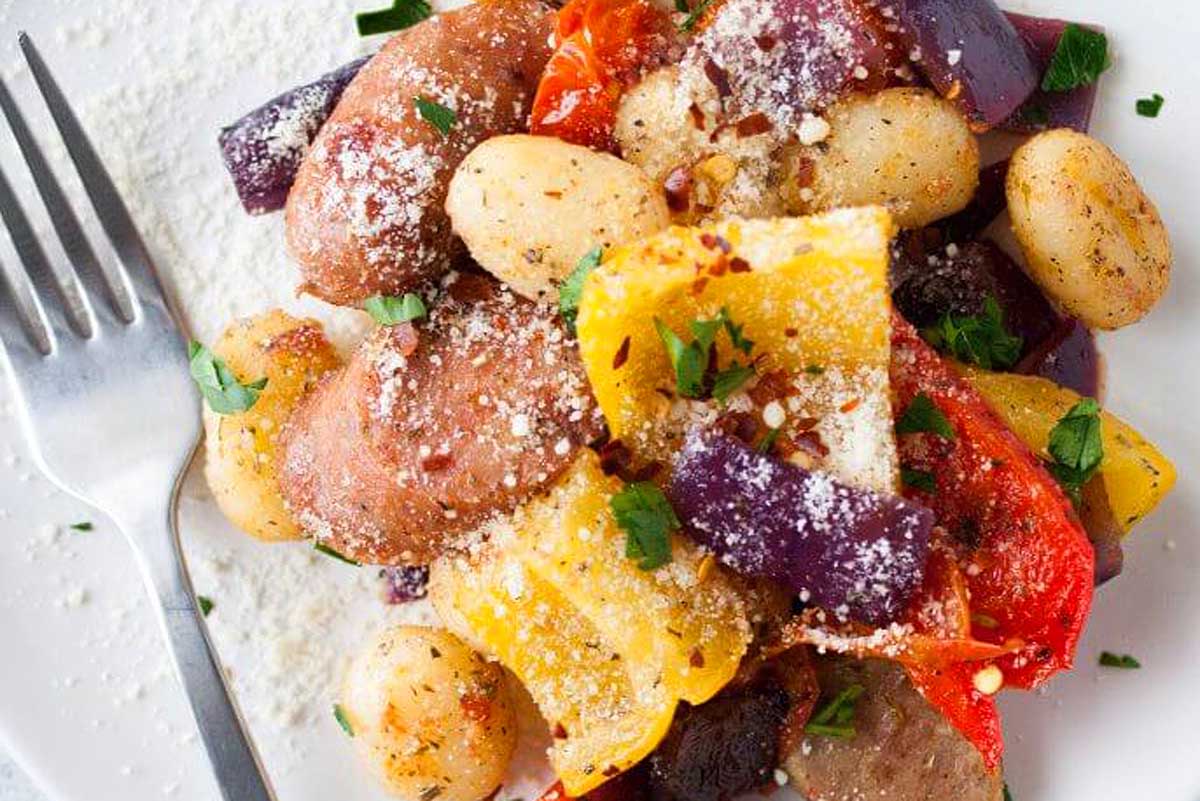 A delicious recipe featuring a plate of sausage, peppers and parmesan.