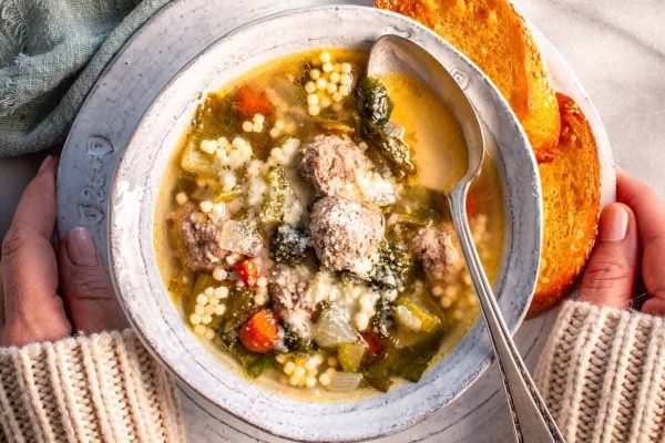 A bowl of soup with meatballs and vegetables.