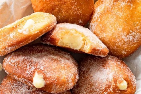Sugared doughnuts in a white bowl.