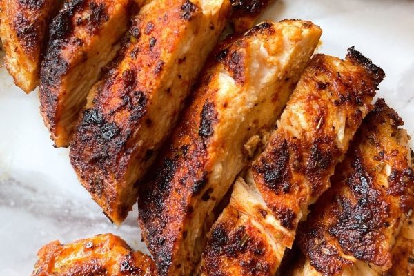 Grilled chicken breasts on a white plate.
