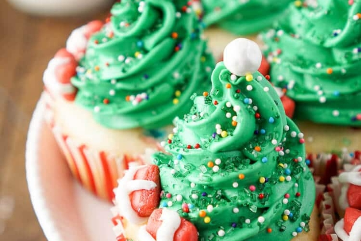 Cute Christmas cupcakes decorated with green frosting and sprinkles.