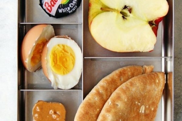A breakfast meal prep with an apple, egg, and peanut butter.