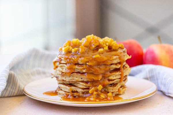 A stack of pancakes with caramel sauce on top.