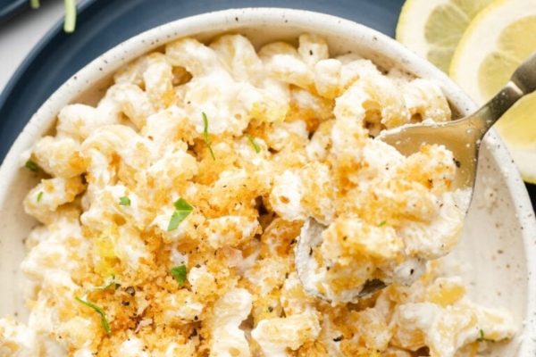 Macaroni and cheese in a bowl with lemon slices.