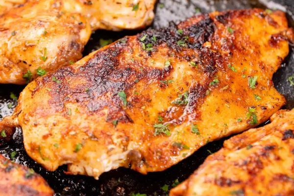 Grilled chicken breasts in a skillet.