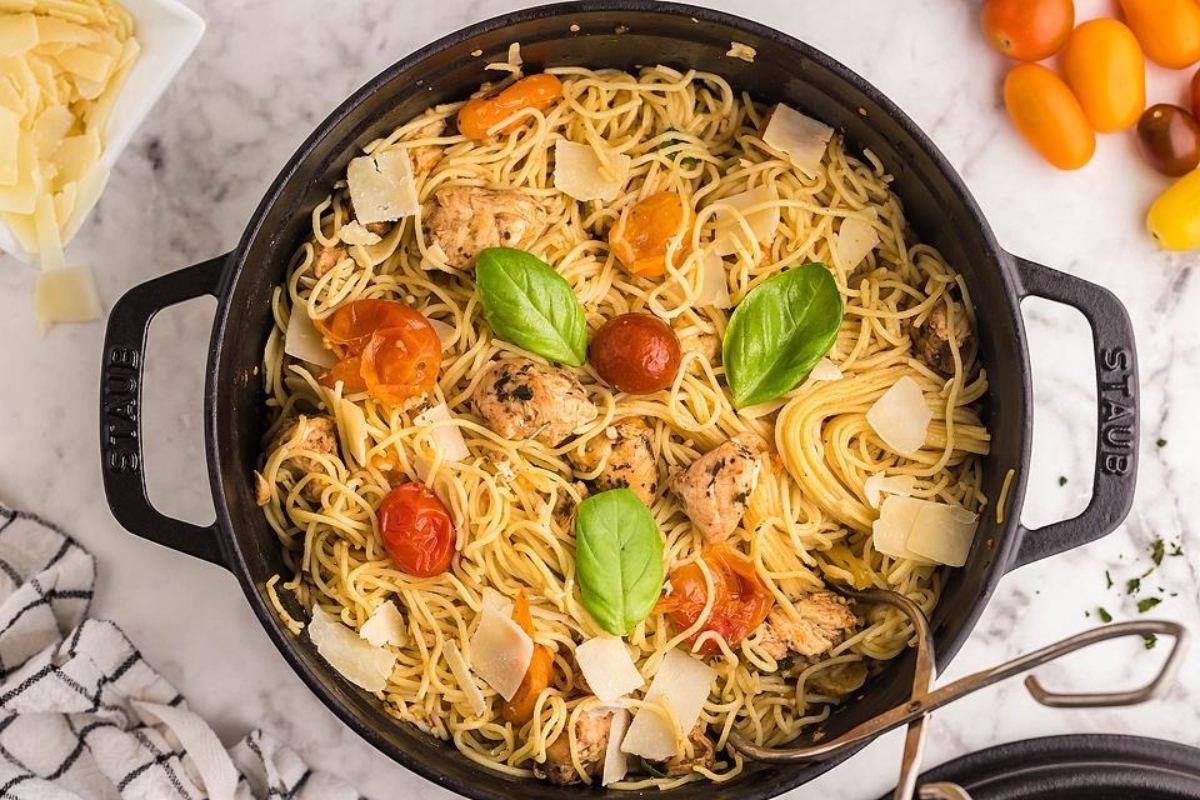 Pasta with chicken and tomatoes in a skillet.