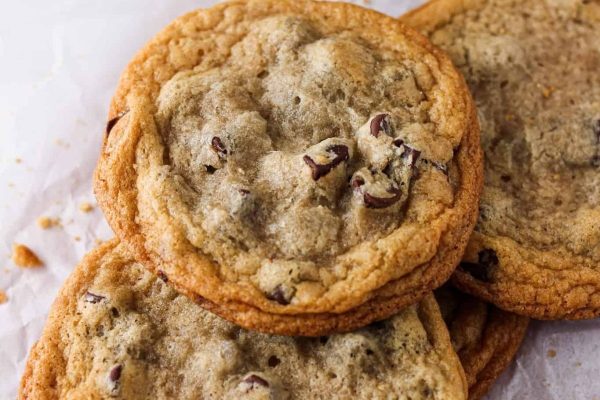 A pile of chocolate chip cookies on a piece of paper.