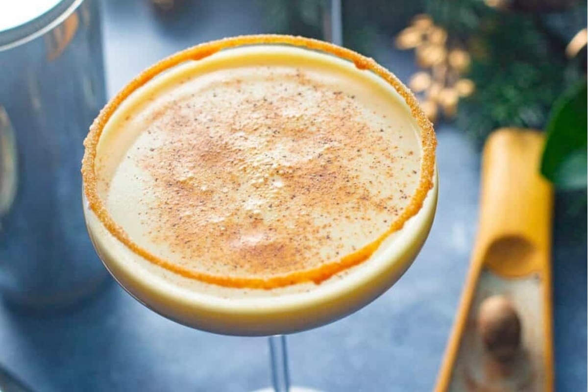 A Christmas cocktail with cinnamon and nutmeg in a glass.