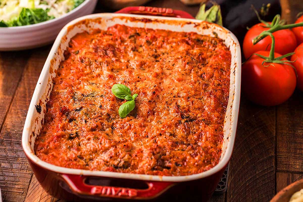 A dish of lasagna on a wooden table.